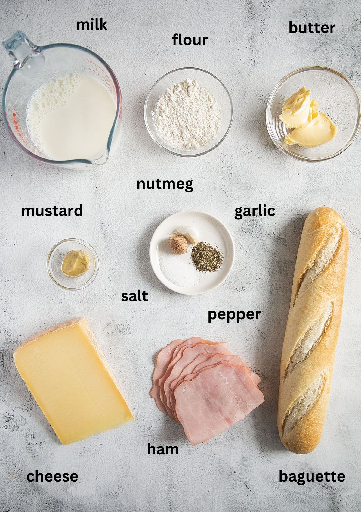 labeled ingredients for making croque monsieur with baguette, cheese, and ham.