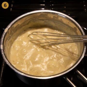 bubbling bechamel sauce in a saucepan stirred with an egg whisk.