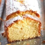 sliced orange drizzle cake sprinkled with lots of icing sugar.