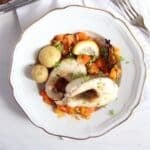 oven baked pike pieces, vegetables and potatoes on a vintage plate.