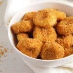 many golden papanasi fierti or romanian cottage cheese dumplings in a small bowl.