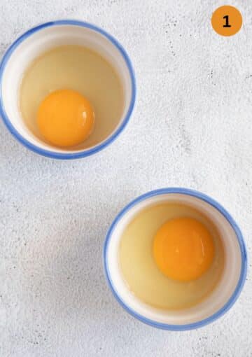 two cracked eggs in two small ramekin cups.