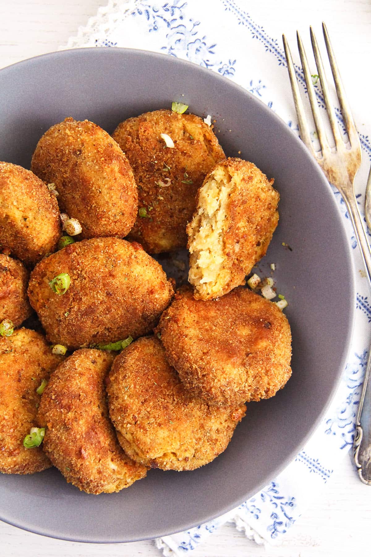 cauliflower potato patties arrange in a bowl and sprinkled with parsley.