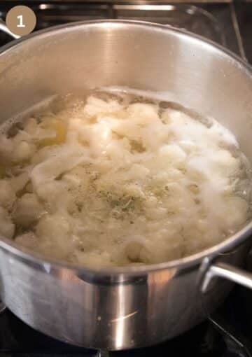 cooking potatoes and cauliflower florets for making patties in bubbling water in a large pot.