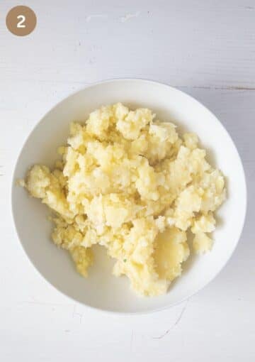 mashed cauliflower and potatoes for making patties in a large bowl.