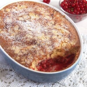 red currant cobbler dessert topped with flaked almonds in a baking dish.