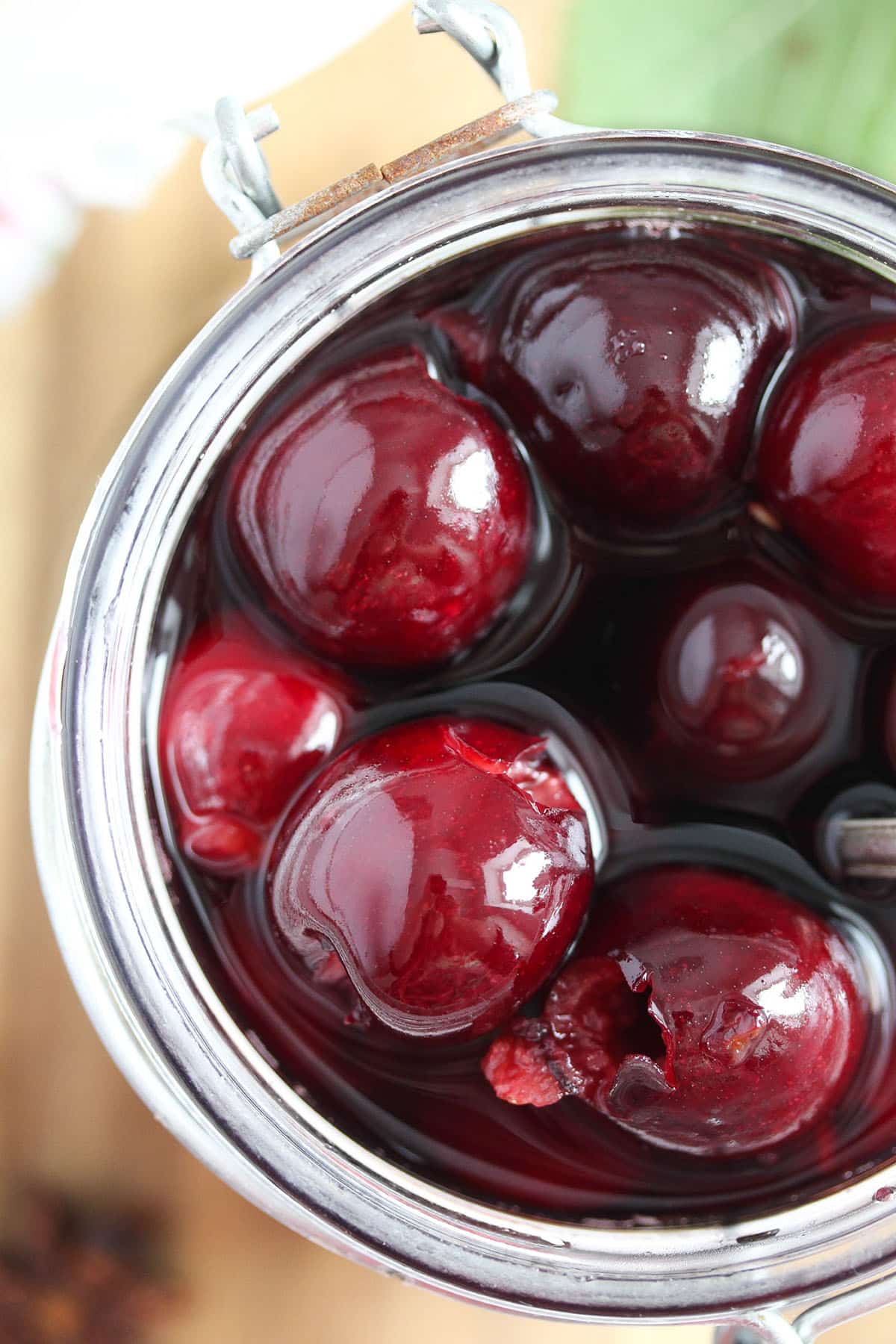 glossy cherries in red wine in a large jar.