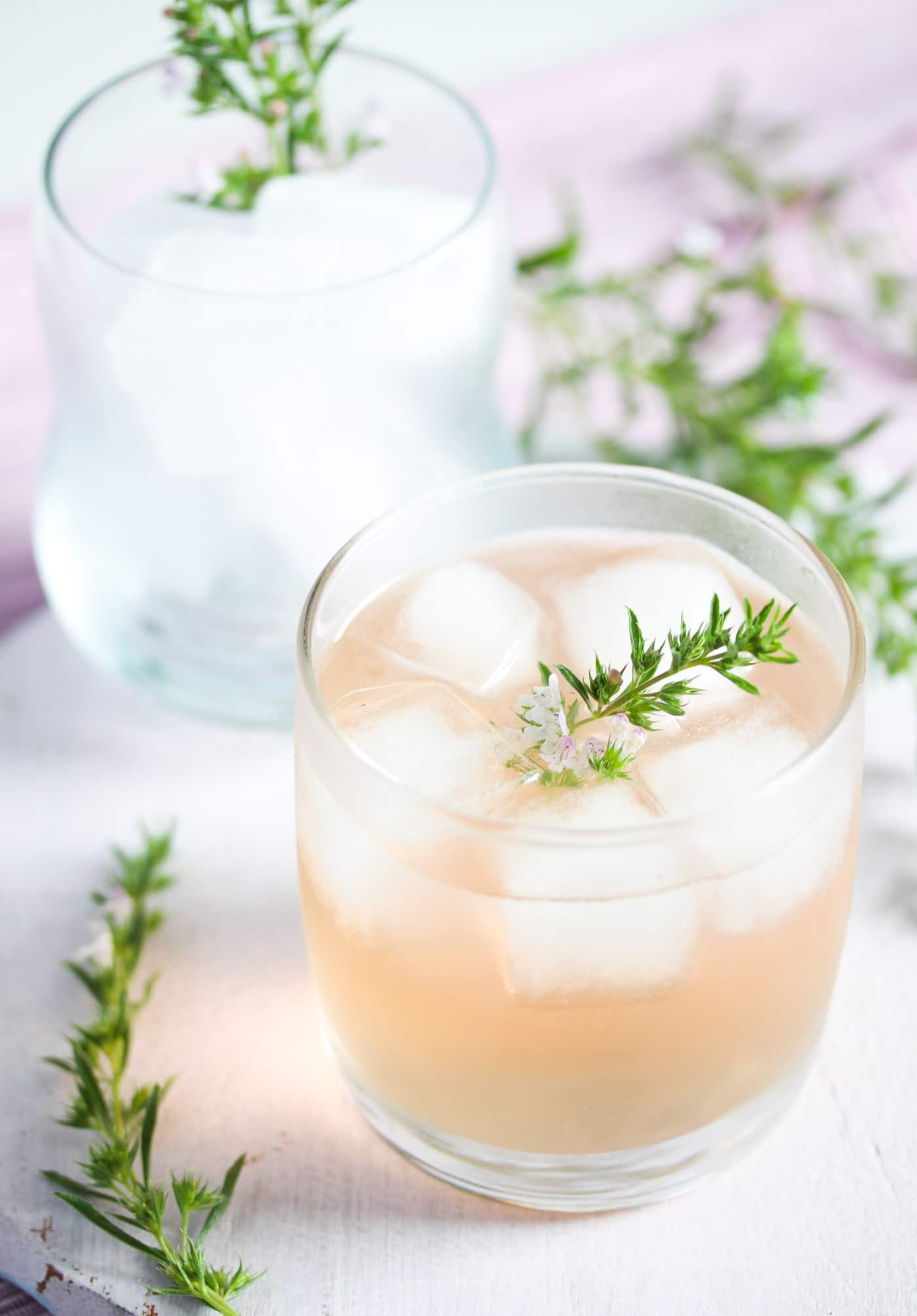 ginger and rhubarb gin in a small glass with thyme on top