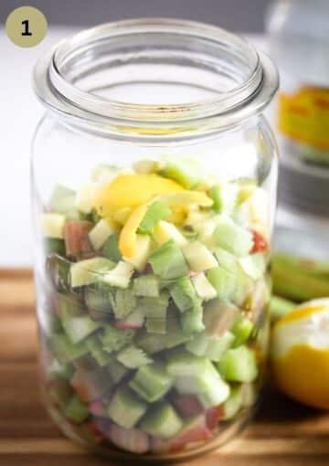 chopped rhubarb and lemon peel strips in a tall jar for making infused gin.