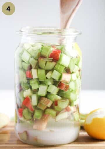 chopped rhubarb. ginger and sugar in a tall jar for making rhubarb infused gin.