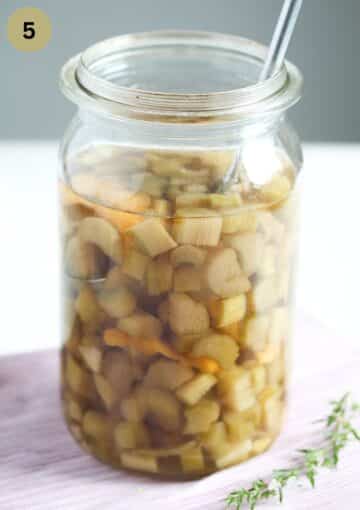 a tall jar full of rhubarb infused gin before straining.