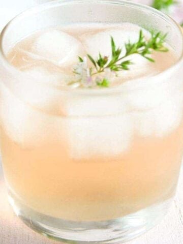 glass with flavored alcohol and a twig of thyme