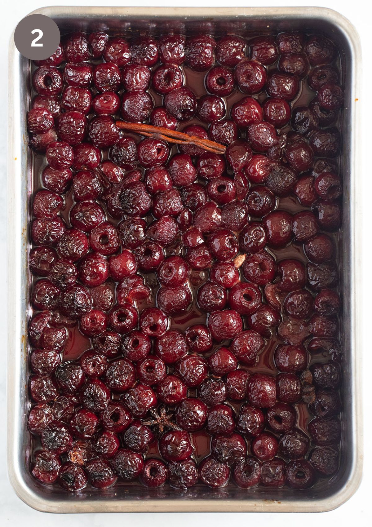 many roasted cherries in a roasting tin.