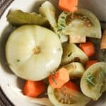 one whole romanian pickled tomato and one more slice with carrot pieces in between.