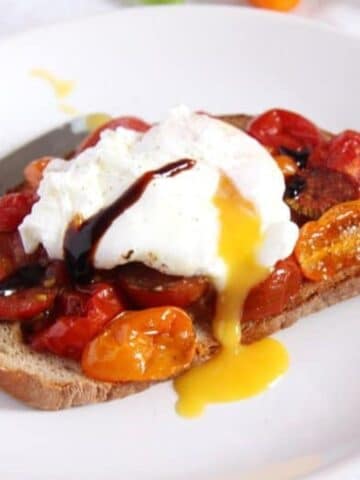 tomato egg toast with an oozing poached egg on top.