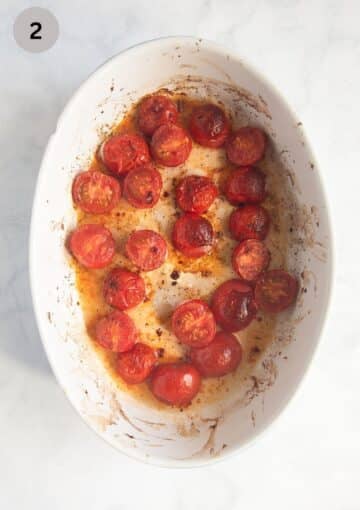 small roasted tomatoes in a small oval baking dish.