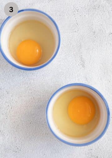 two cracked eggs in rameking dishes ready to be poached.