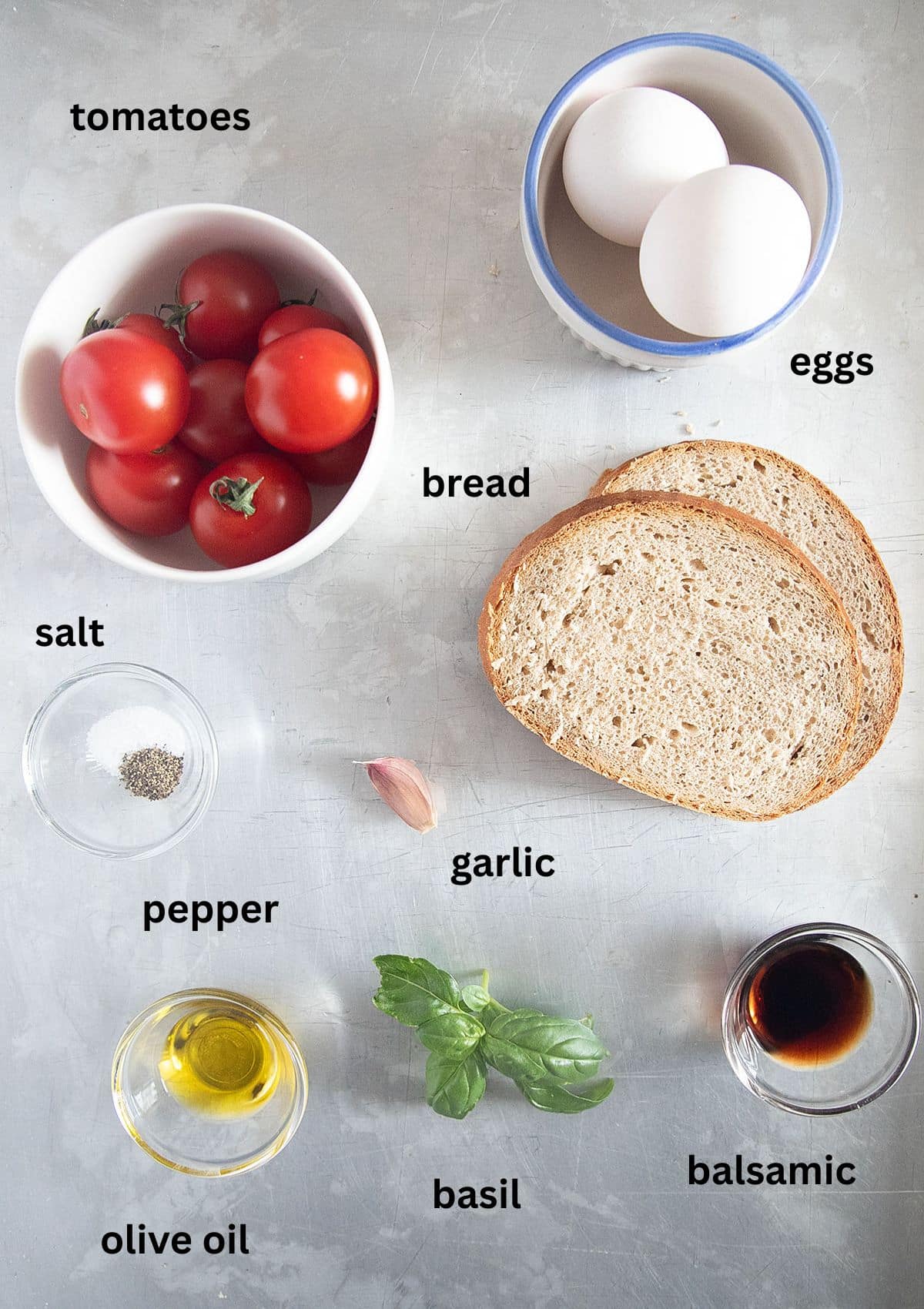 labeled ingredients for making eggs and tomatoes with olive oil, balsamic, basil. bread, garlic and seasoning.