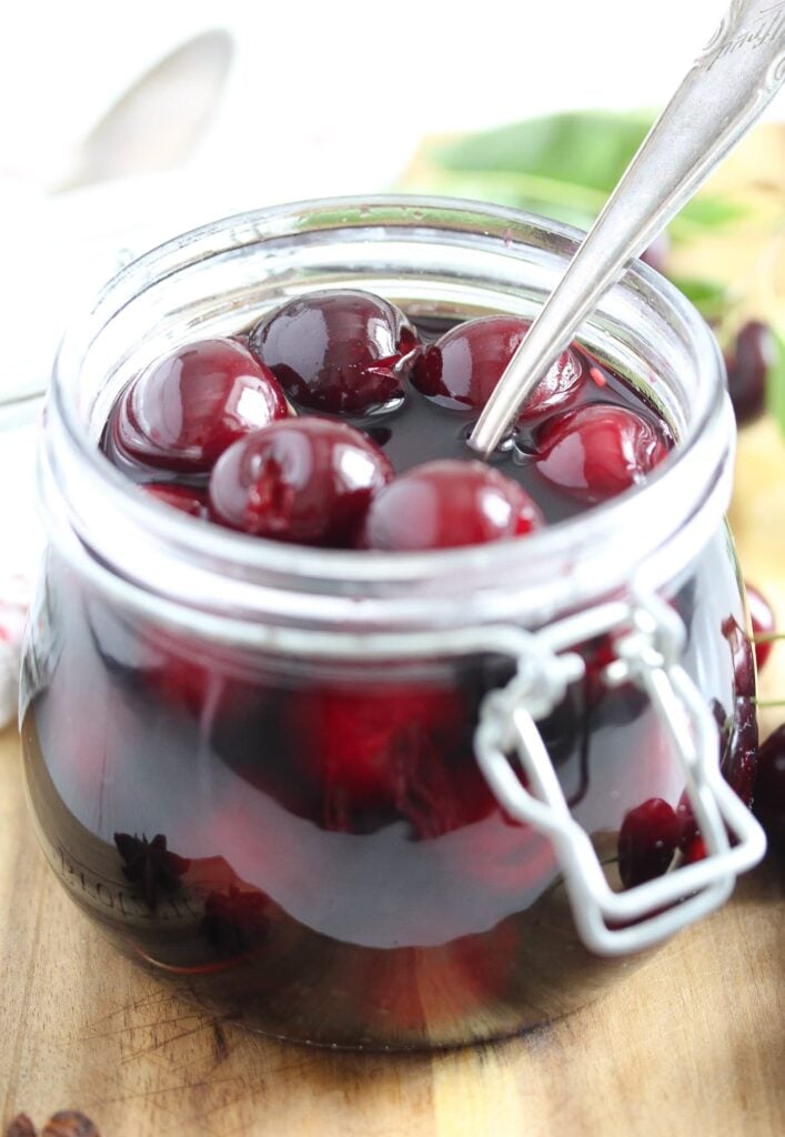 preserved cherries in red wine in an open jar