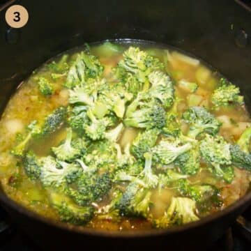 adding broccoli florets to a pot of soup.