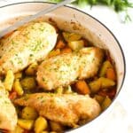 chicken breast pieces on a bed of potatoes and carrots