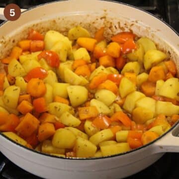 chopped carrots, peppers and potatoes cooking in a large dutch oven.