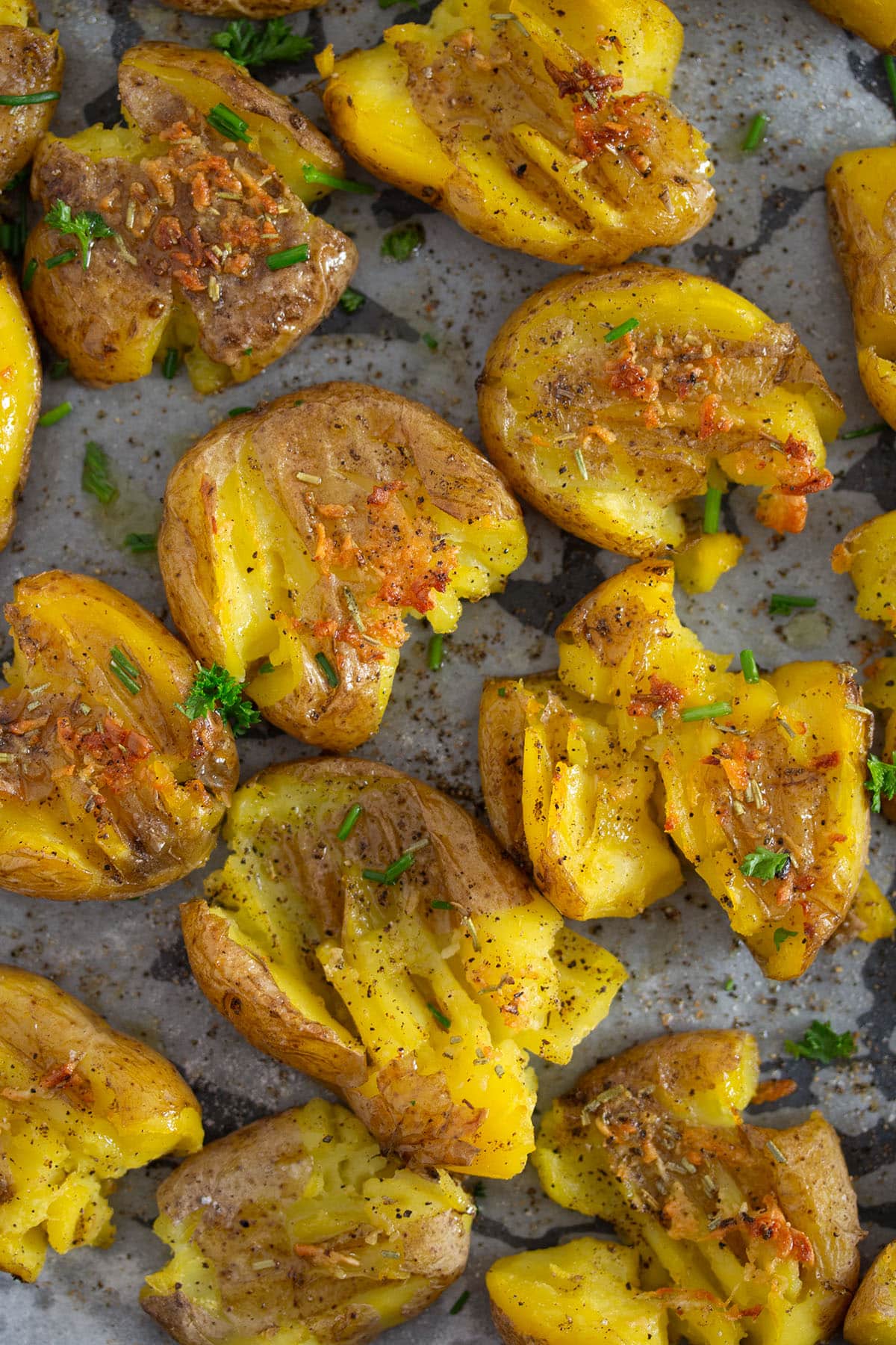 fingerlings smashed with olive oil and garlic on a baking sheet. 