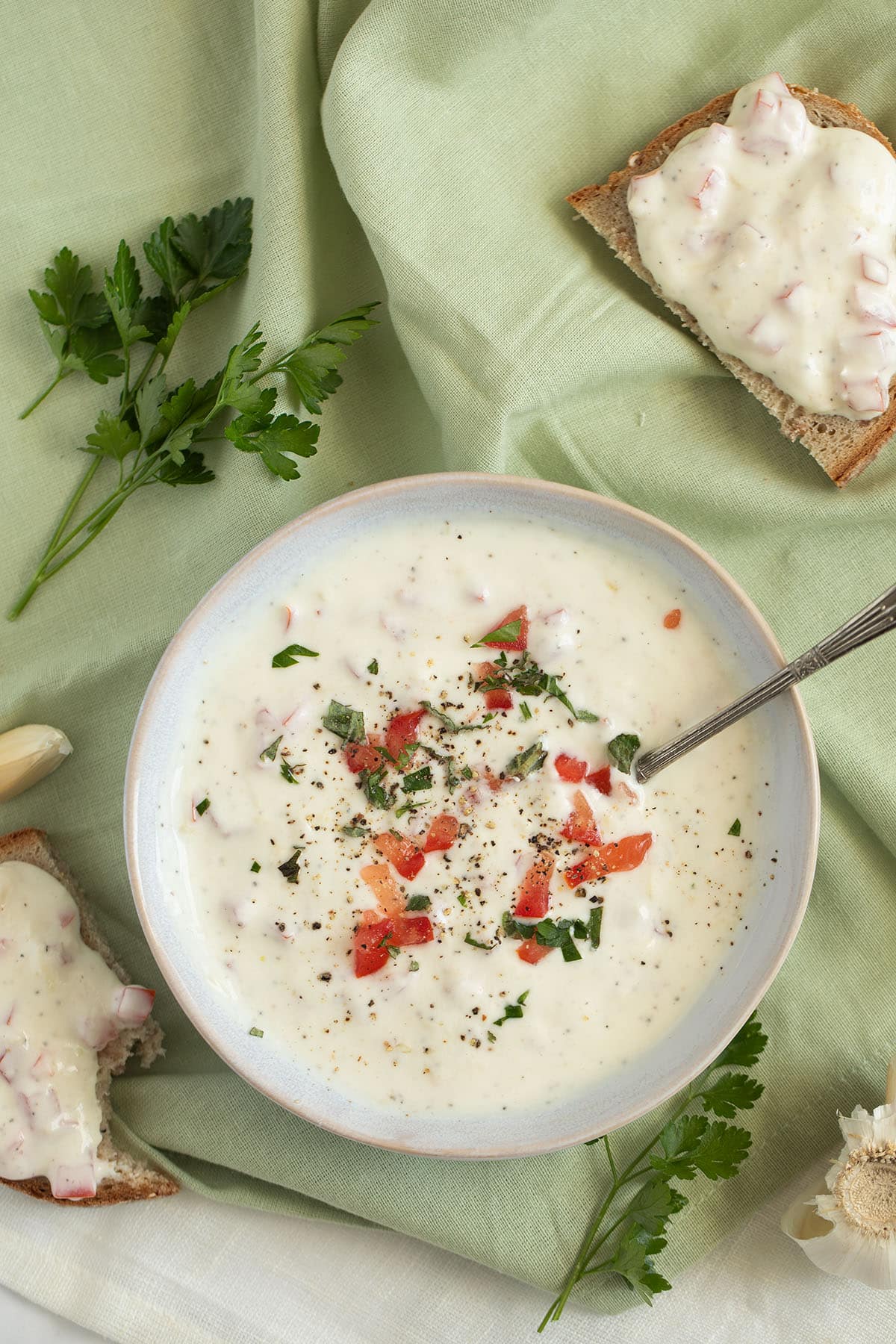 garlic sour cream sauce with tomato pieces and parsley on top.