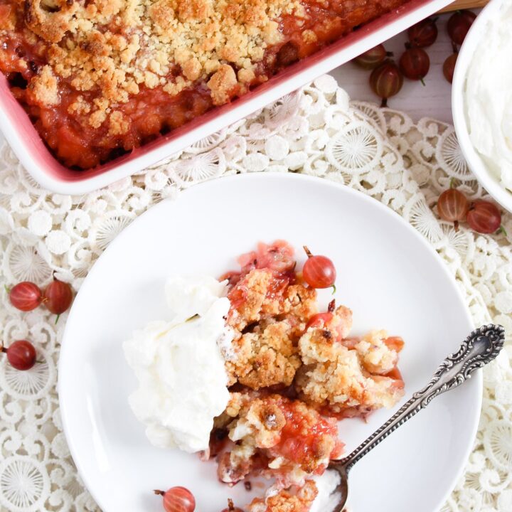 berry dessert served with whipped cream on a white plate