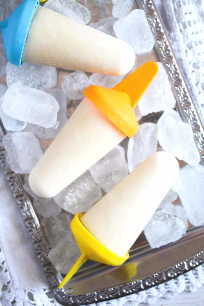 lime popsicles on a silver platter with ice cubes