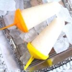 lime popsicles on a silver platter with ice cubes.