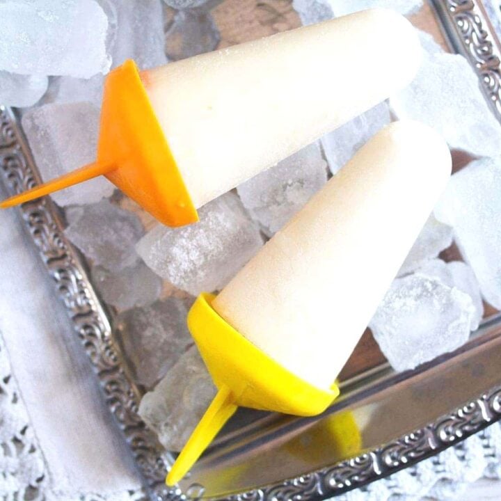 lime popsicles on a silver platter with ice cubes