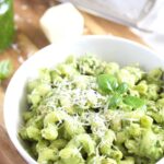 pesto tuna pasta in a white bowl on the table serve with parmesan
