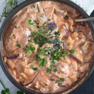 persian eggplant dip sprinkled with parsley and purple edible flowers.