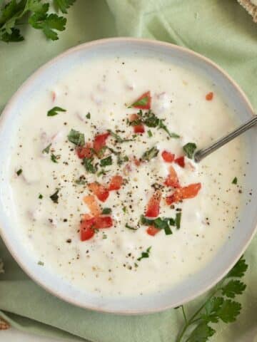 the best garlic sour cream sauce in a bowl with a spoon in it.