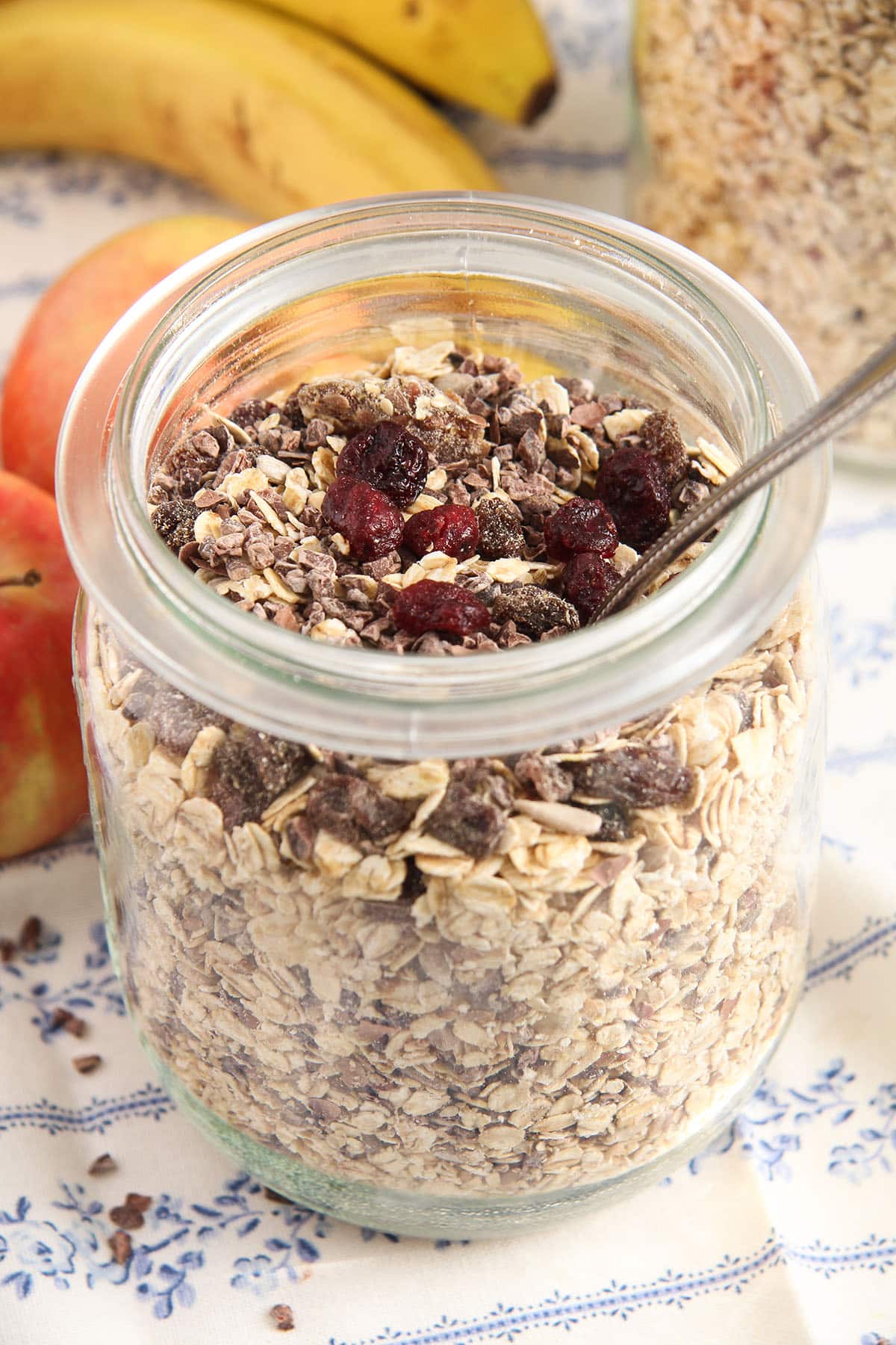 jar of muesli without sugar mixture, topped with raising and cranberries.