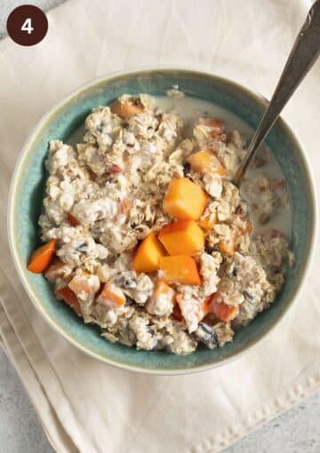 bowl with sugar free muesli served with chopped parsimmons, yogurt and milk.