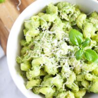 close up green tuna pasta sprinkled with parmesan and topped with basil leaves