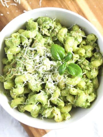tuna pesto pasta sprinkled with parmesan in a white bowl seen from above