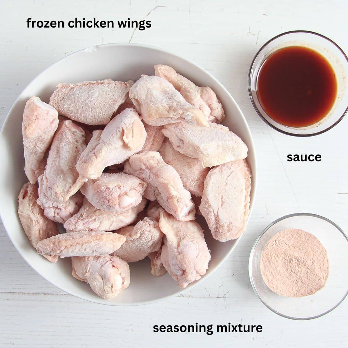 labeled bowls with frozen chicken wings, seasoning mixture and sauce.