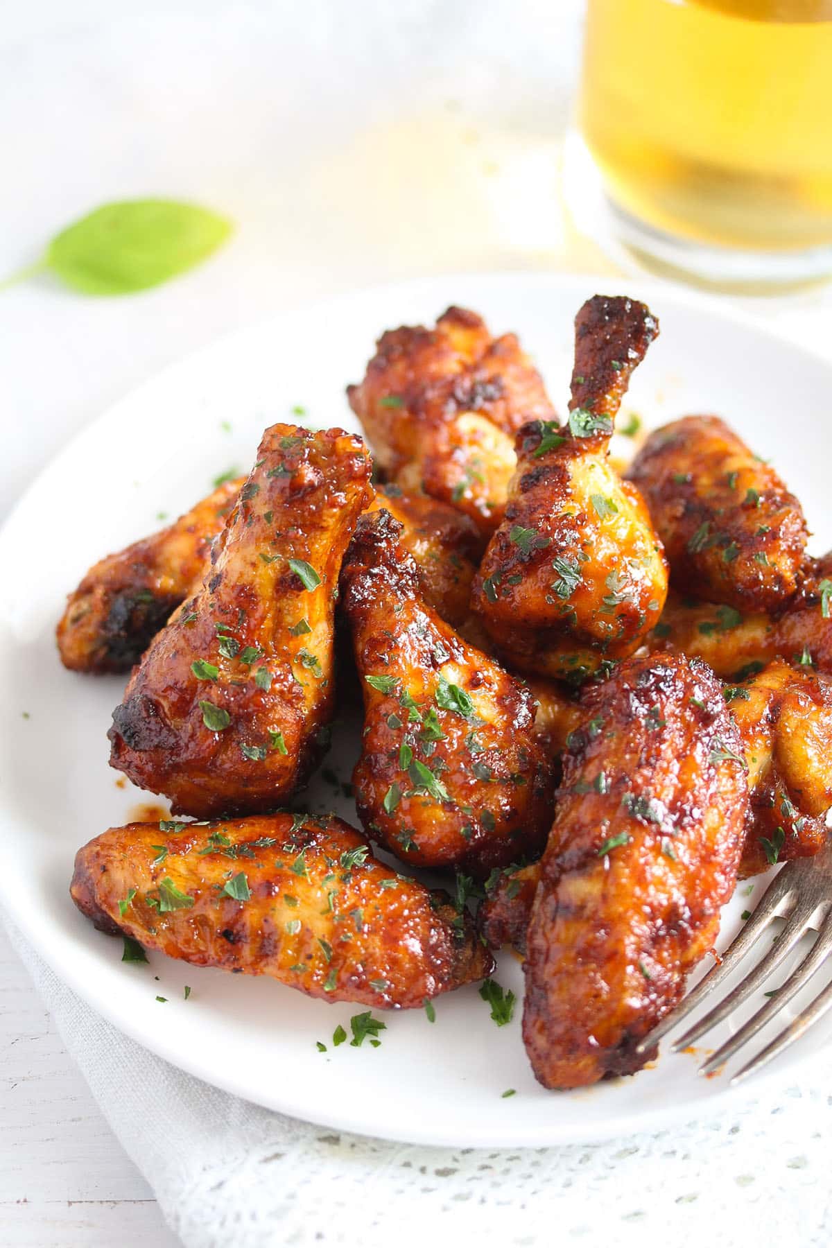 a bunch of golden brown chicken wings on a plate with a fork.