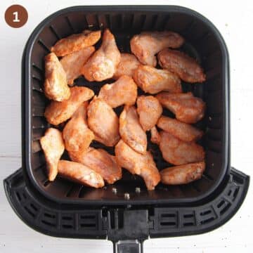 frozen chicken wings in the air fryer basket.