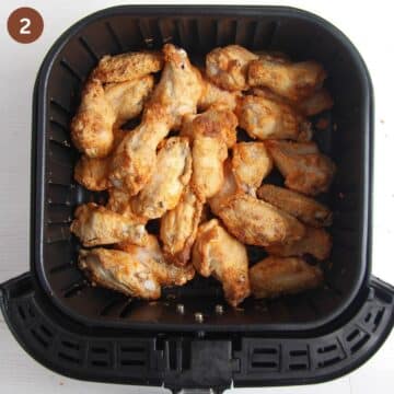 half-cooked chicken wings in the air fryer basket.
