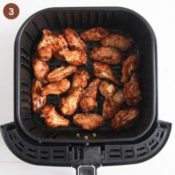 cooked wings in the air fryer basket.