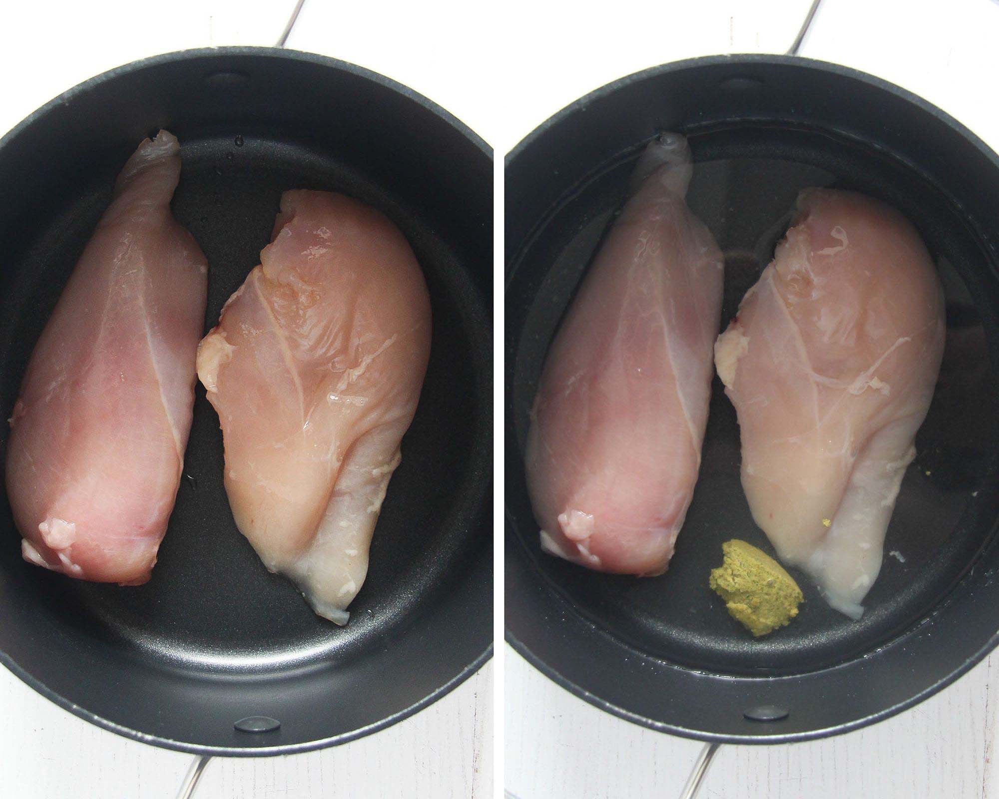 two pieces of raw chicken breast in a small black pot