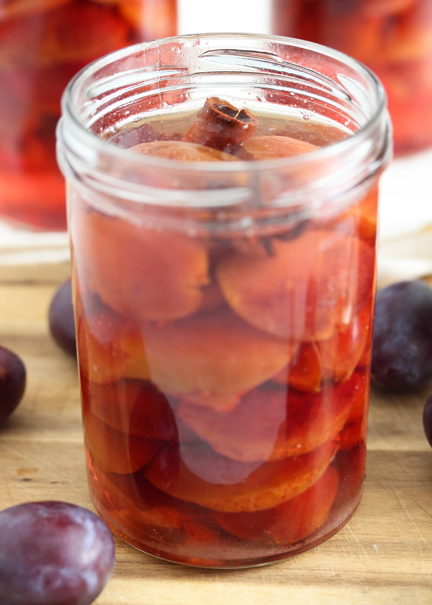 Italian plums canned in jars on a cutting board