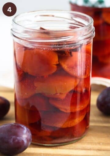 a jar of plums in syrup before canning it.
