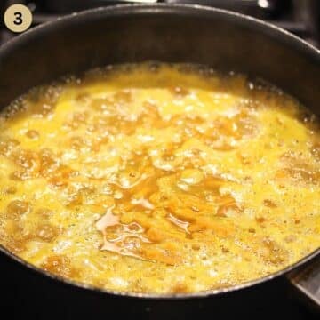 simmering rice with carrots in a large saucepan.