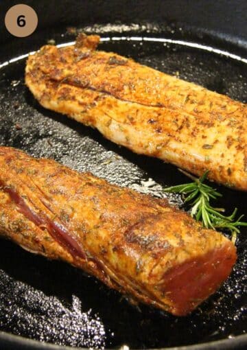 searing two pieces of pork with rosemary in a cast iron skillet.