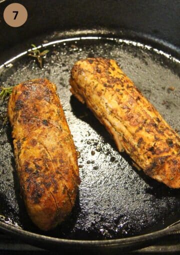 two pieces of pork tenderloin being cooked in a large skillet.